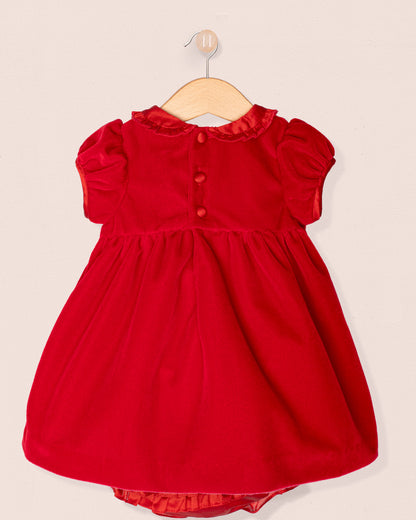 Red dress on a hanger against a beige background