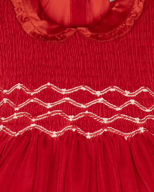 Close-up of a red velvet with white smocking
