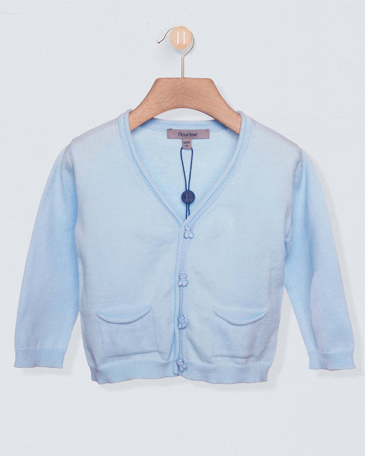 Light blue cardigan sweater with bear buttons on a light grey background