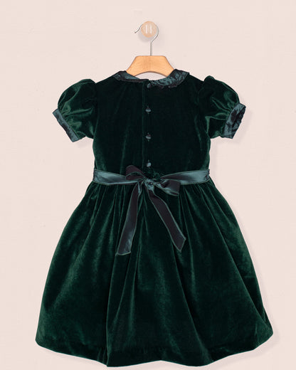 Green velvet dress with a belt on a beige background