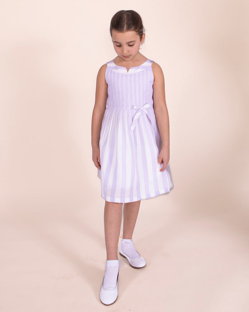 girl standing wearinf vienna stripe dresss and white shoes