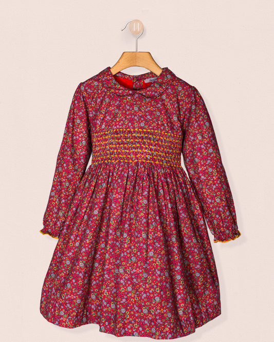 Red floral dress with smocked waist on a beige background