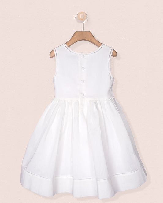 White dress on a hanger against a light pink background