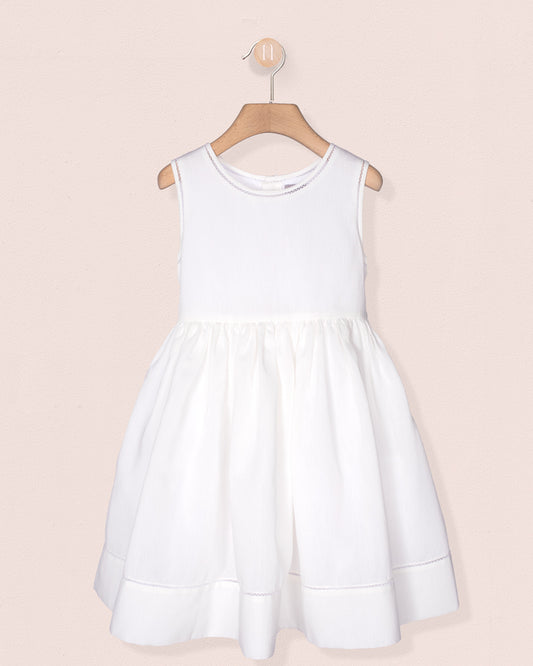 White dress on a hanger against a light pink background