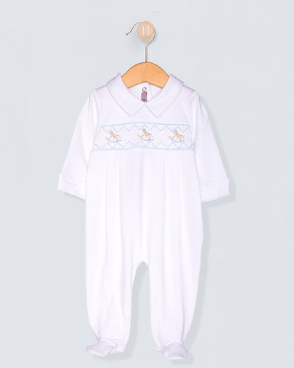 White baby romper with embroidered details on a light gray background