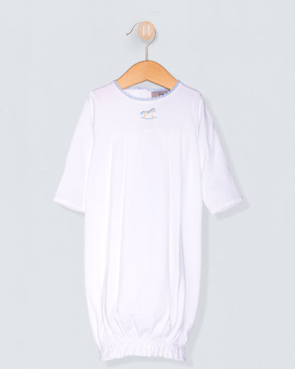 White baby gown on a wooden hanger against a light gray background