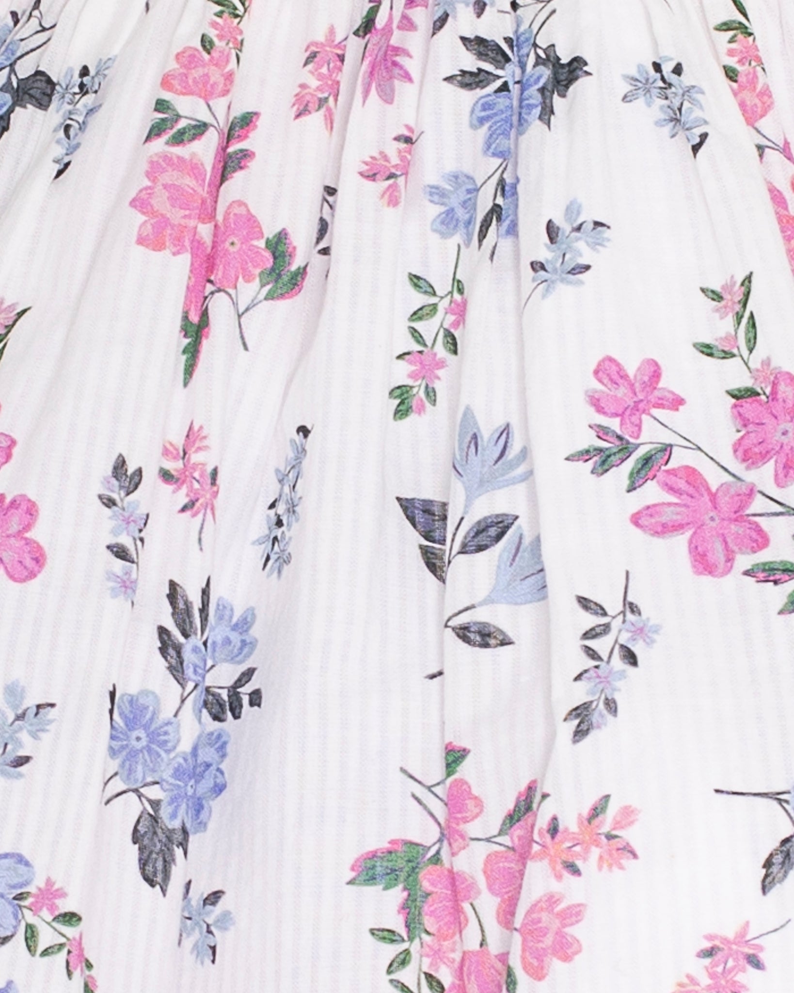 Detail of pink smocking across the bodice and delicate pink and purple floral print on white cotton voile fabric with fine vertical texture.