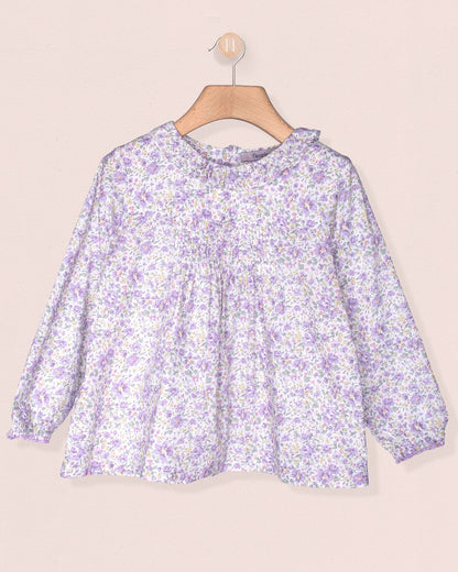 Floral blouse on a hanger against a beige background