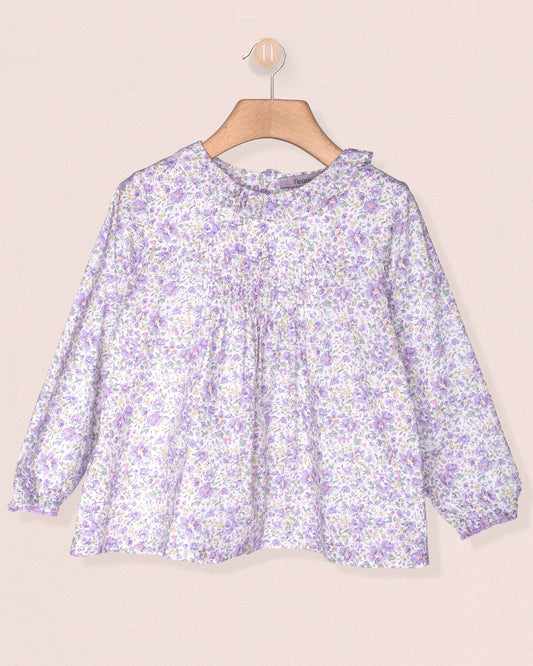 Floral blouse on a hanger against a beige background