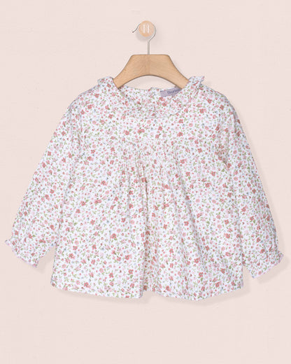 Floral blouse on a hanger against a beige background