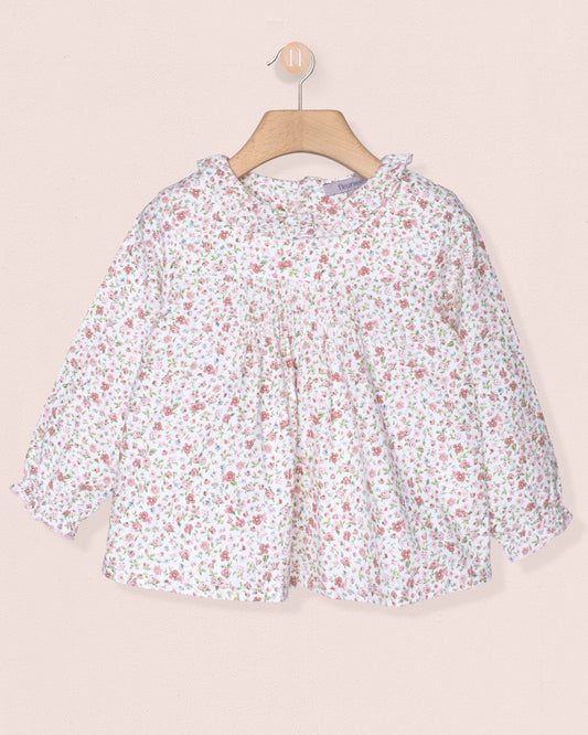 Floral blouse on a hanger against a beige background