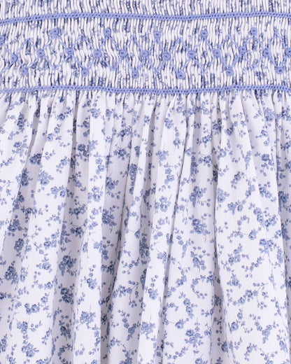 Close-up of the smocked bodice with delicate blue floral print and fine stitching detail