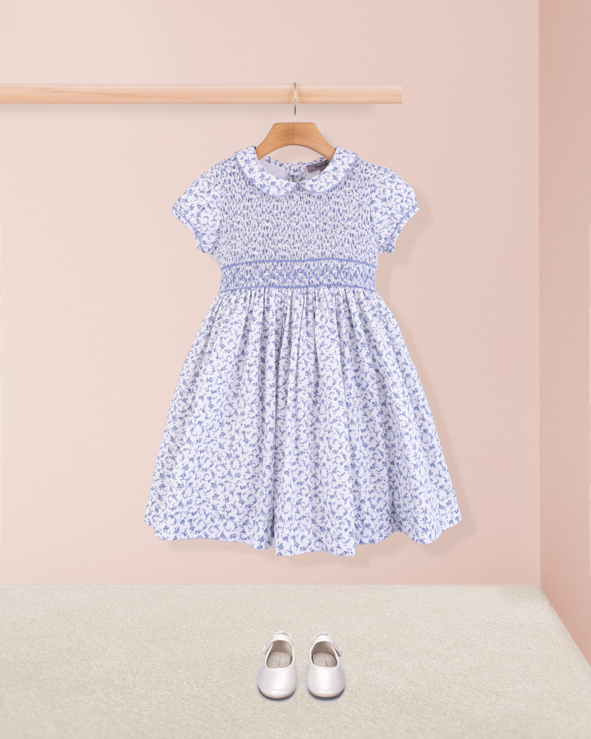 Full front view of Amanda Campari blue floral smocked dress with white Mary Jane shoes beneath