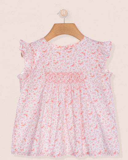 Floral dress on a hanger against a beige background
