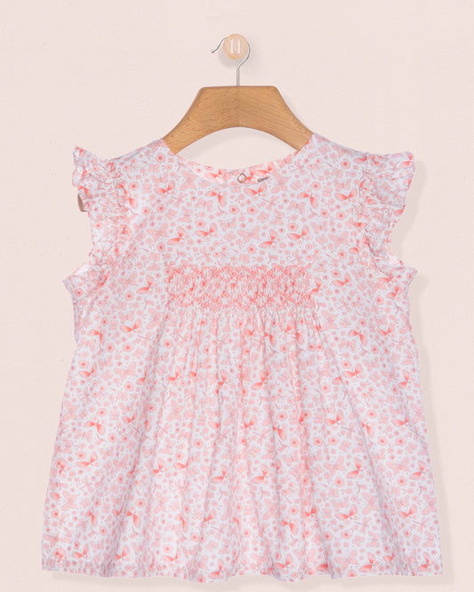 Floral dress on a hanger against a beige background