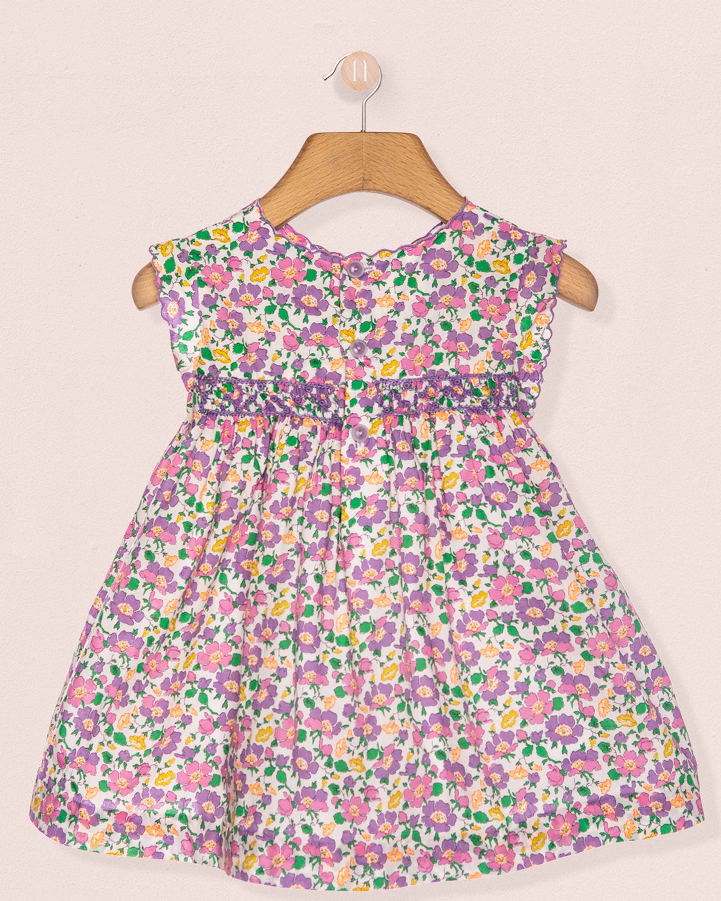 Floral dress on a hanger against a plain background