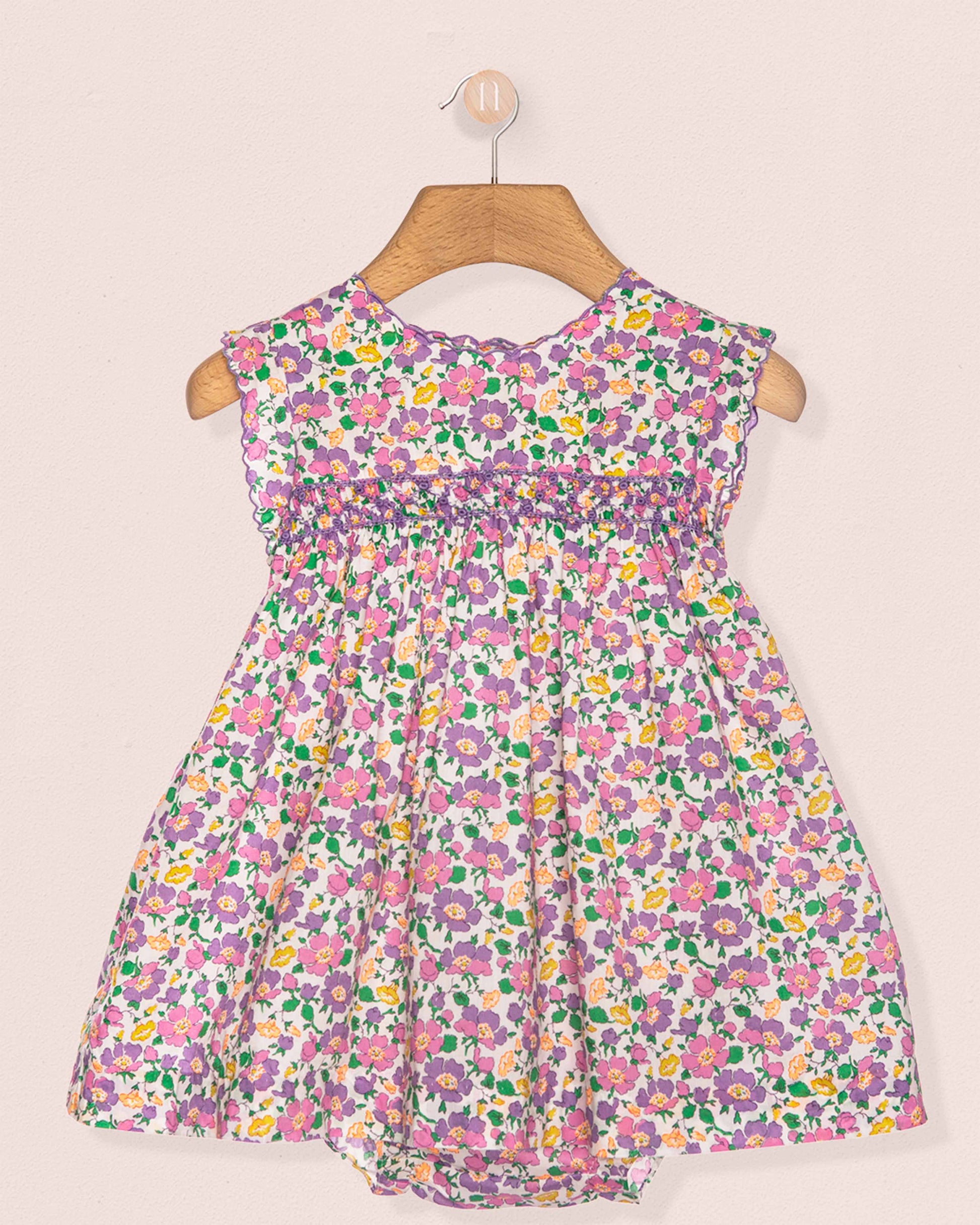 Floral dress on a hanger against a beige background