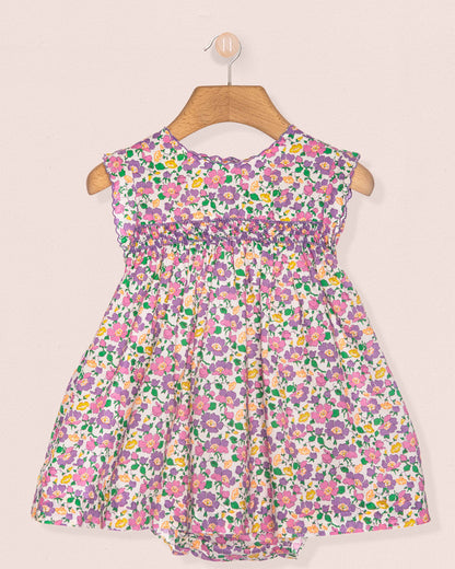 Floral dress on a hanger against a beige background