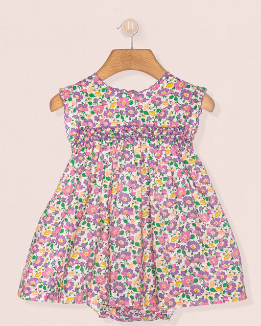 Floral dress on a hanger against a beige background