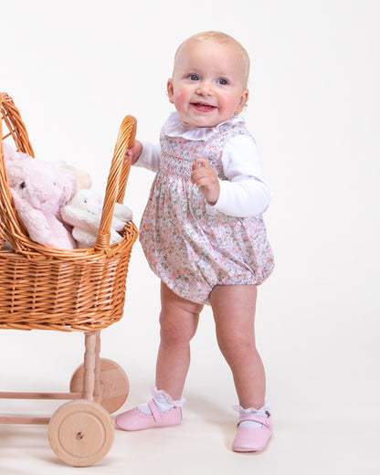 Baby girl wearing Kensington Lauren Pink Floral Romper pushing a carriage full of toy-showing the side of the romper