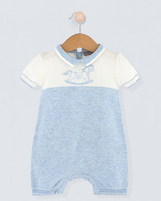 Baby romper with white top and blue knitted bottom on a hanger against a light gray background