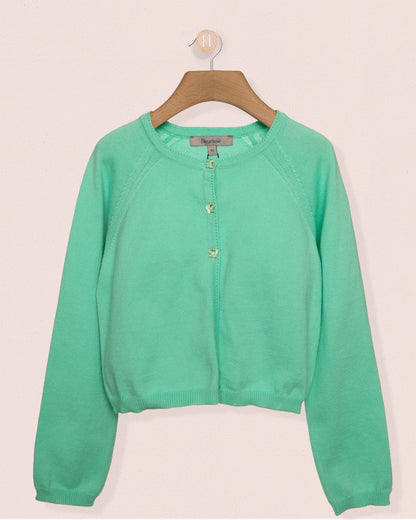 Green sweater on a wooden hanger against a beige background