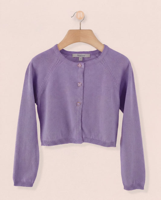 Purple cardigan on a wooden hanger against a beige background