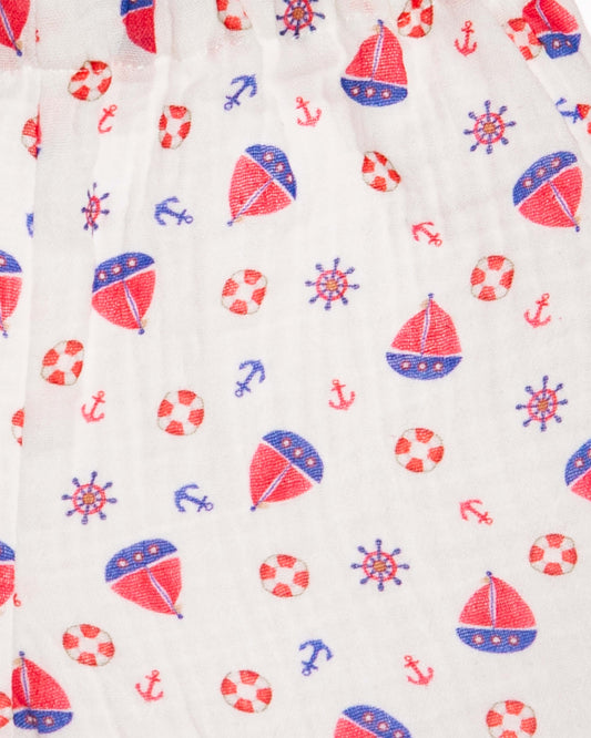 Pattern of sailboats, life buoys, anchors, and wheels on a white background
