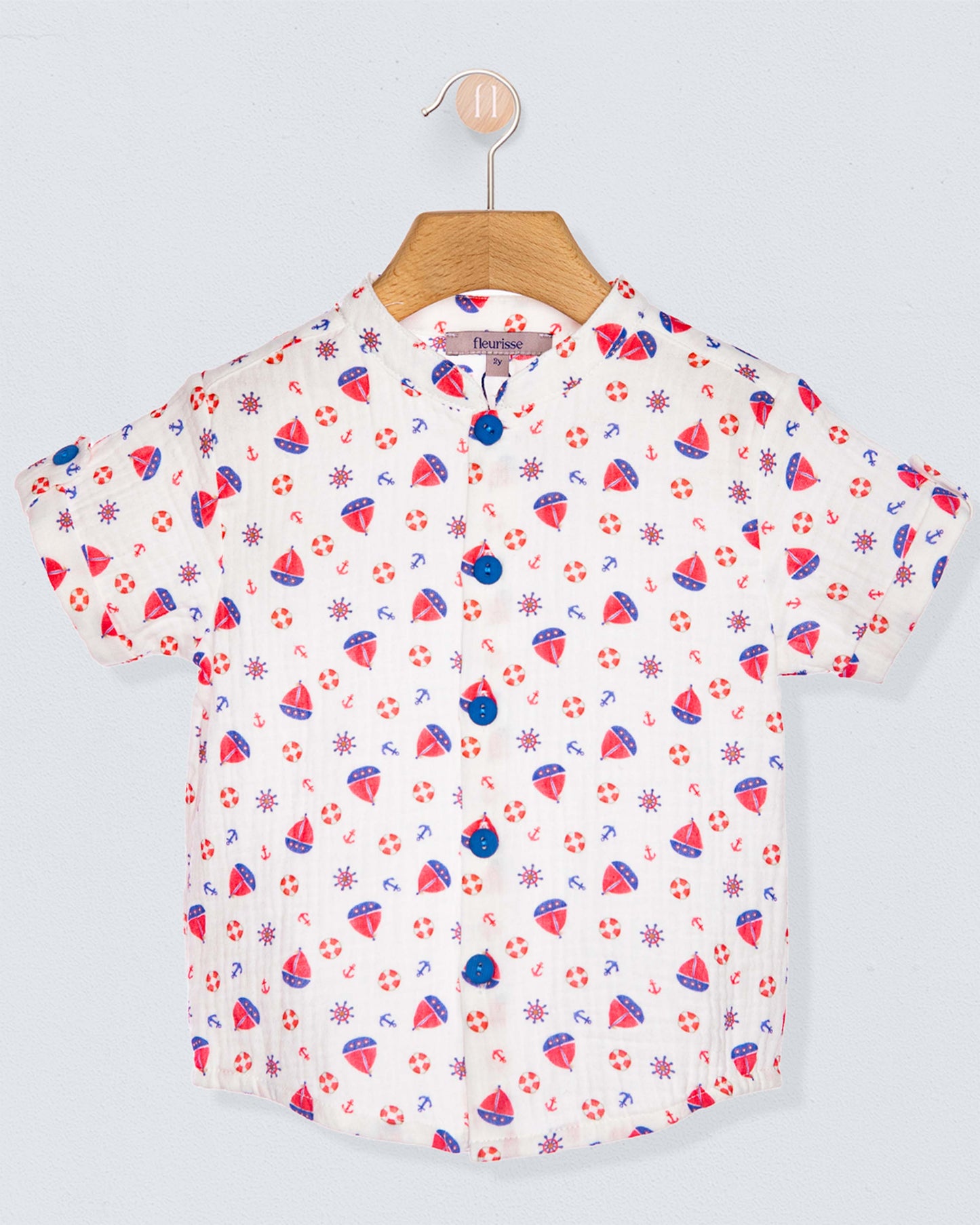 Short-sleeve shirt with colorful pattern on a hanger against a light gray background
