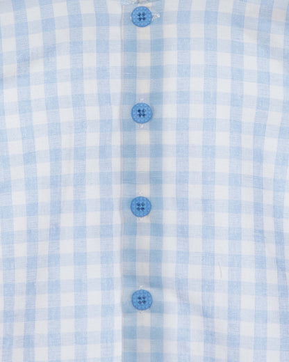 Close-up of a blue and white checkered shirt with buttons.