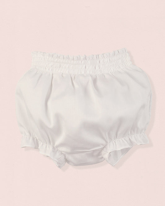 White baby bloomers on a pink background