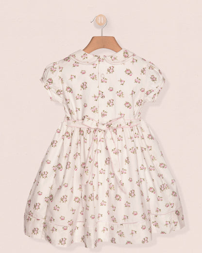 Floral dress on a hanger against a beige background