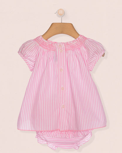 Pink and white striped baby outfit on a hanger against a beige background