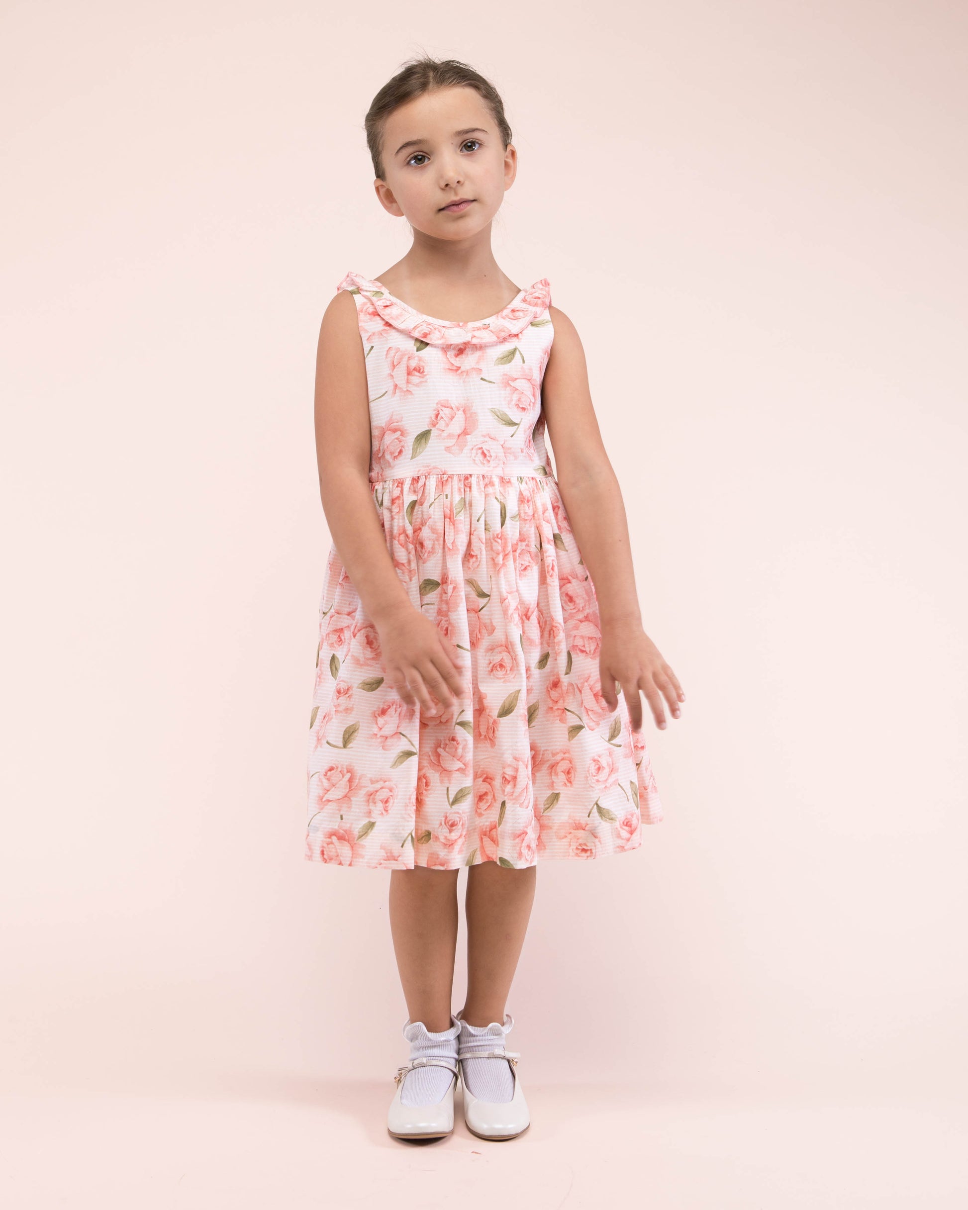Girl standing, wearing the Ella Bianca Roses Dress showing the front of the dress