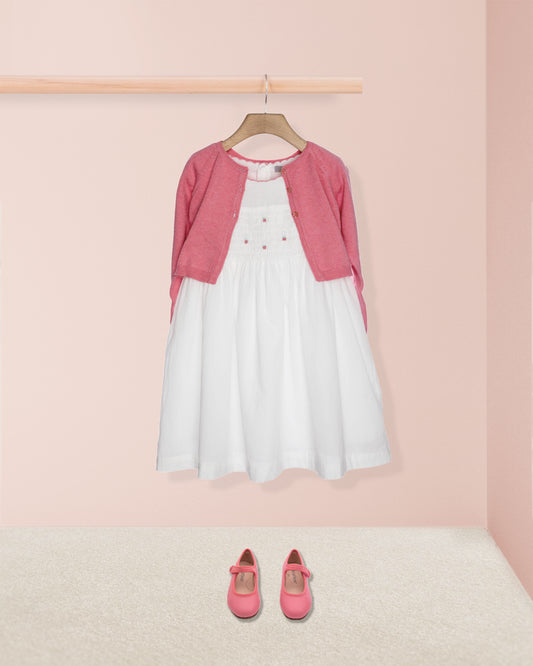 White dress with pink cardigan and shoes on a pink background