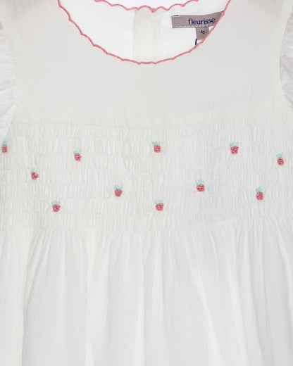 White blouse with strawberry embroidery and 'fleurisse' label.