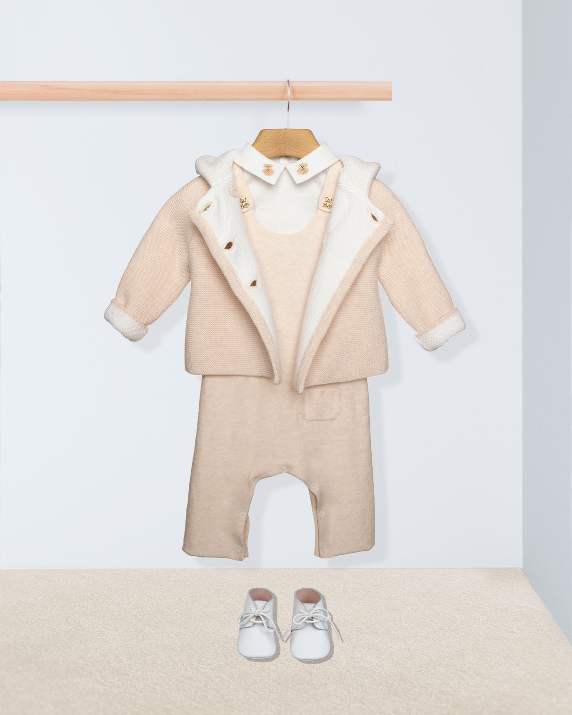 Beige baby outfit with white shoes on a white background