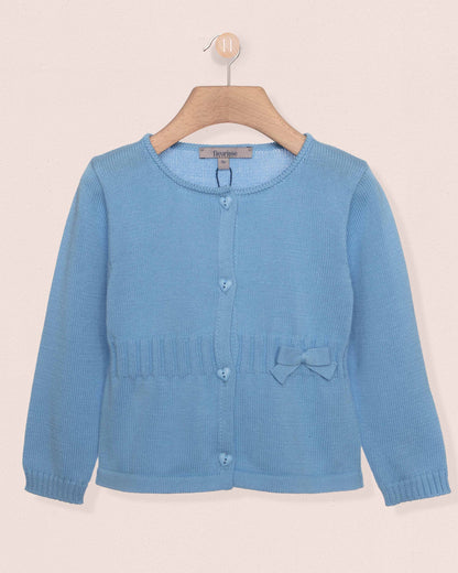 Blue cardigan on a wooden hanger against a beige background