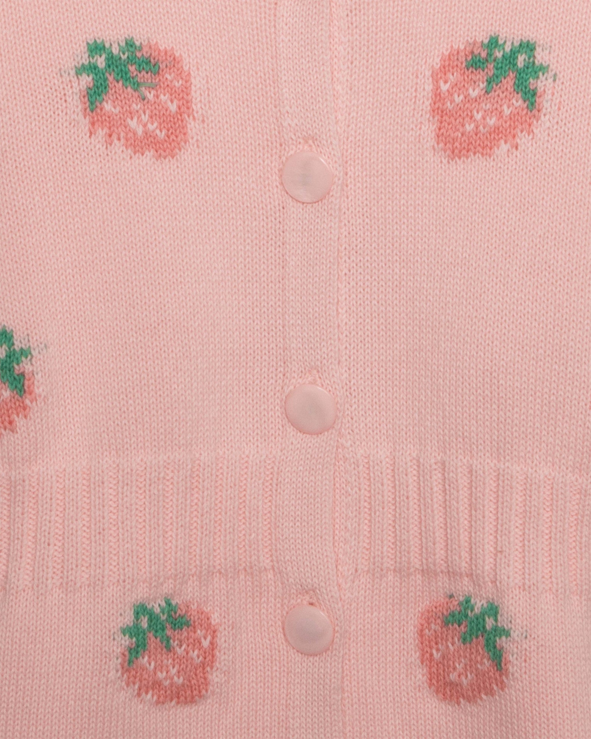 Pink cardigan with strawberry patterns and buttons on a light pink background