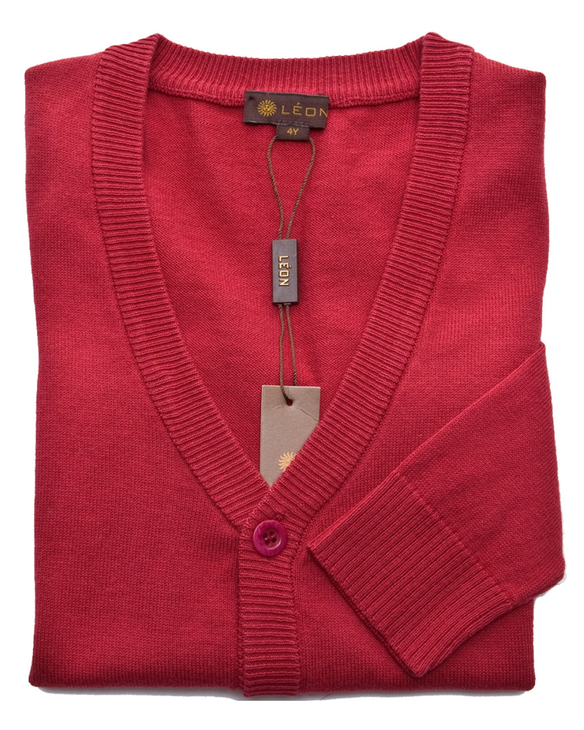 red cardigan sweater for boys with a red button, folded against a white table background