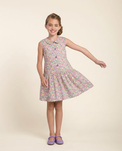 Young girl wearing a floral dress on a beige background