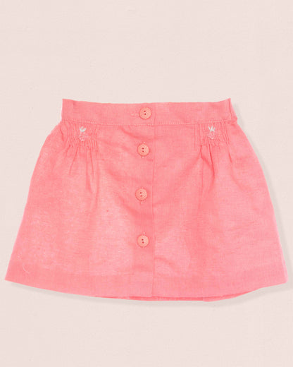 Pink skirt with button details on a light beige background