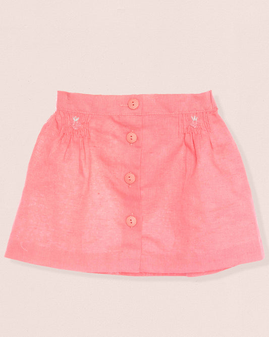 Pink skirt with button details on a light beige background
