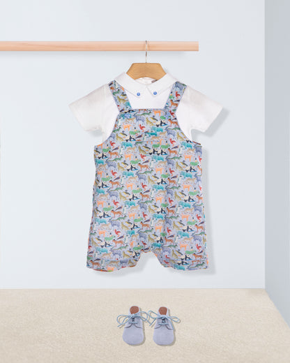 Baby outfit with patterned overalls, white shirt, and blue shoes on a light background