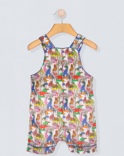 Colorful children's dress with animal pattern on a hanger against a light gray background