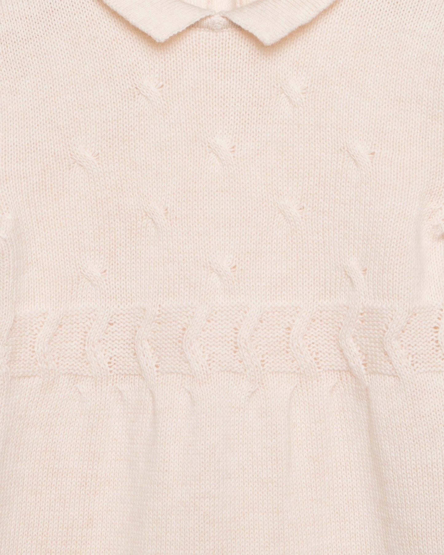 Close-up of a textured beige romper with a collar.