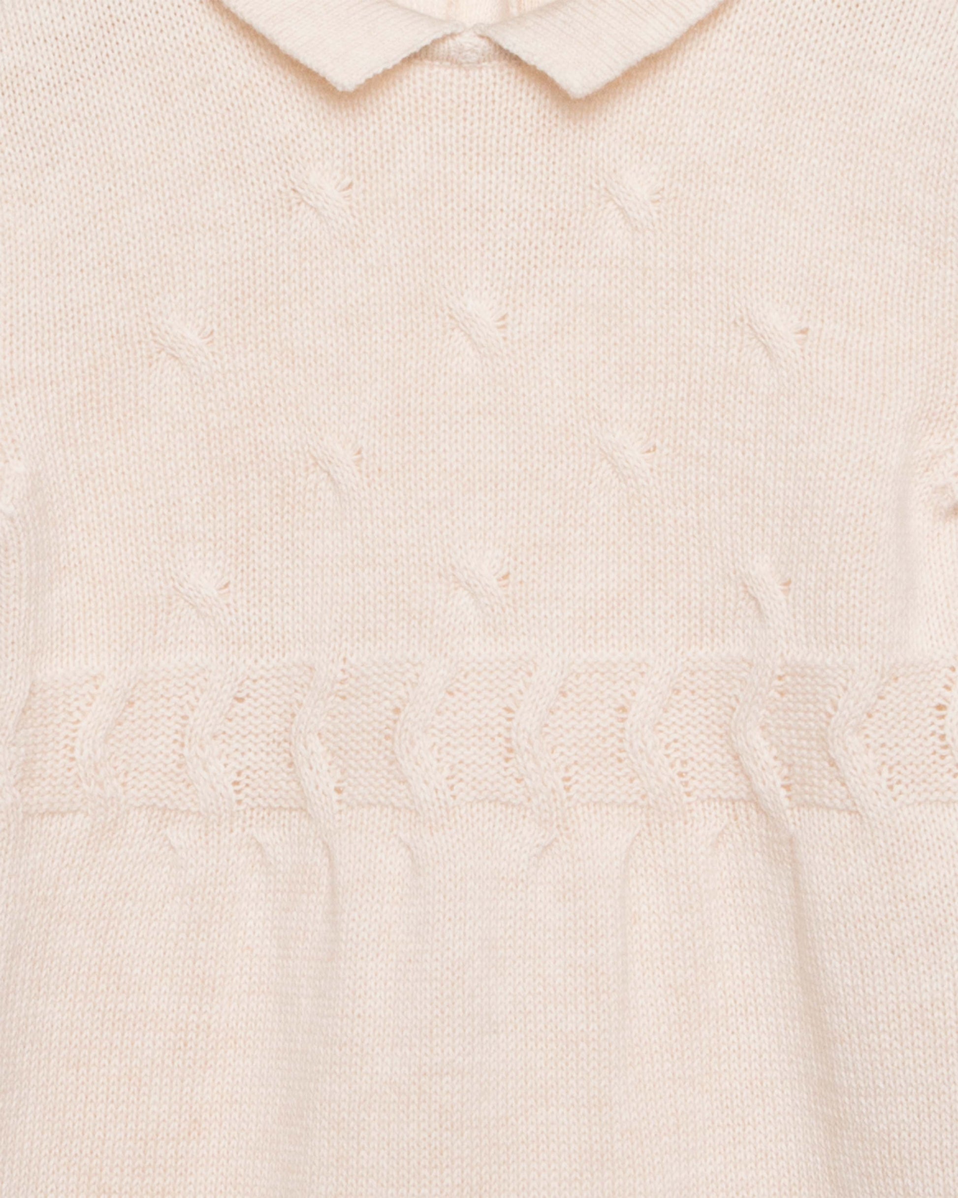Close-up of a textured beige romper with a collar.