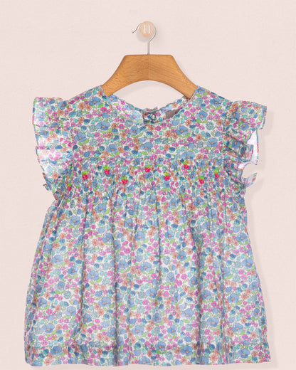 Floral dress on a hanger against a plain background