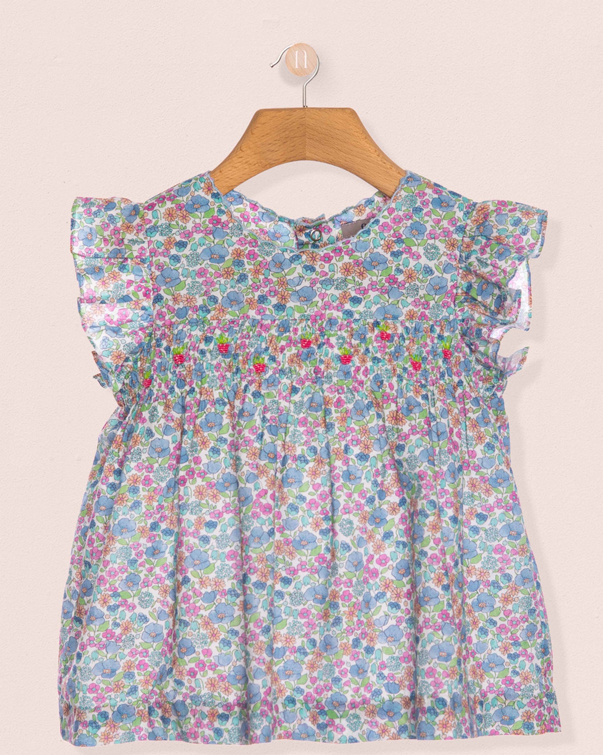 Floral dress on a hanger against a light background