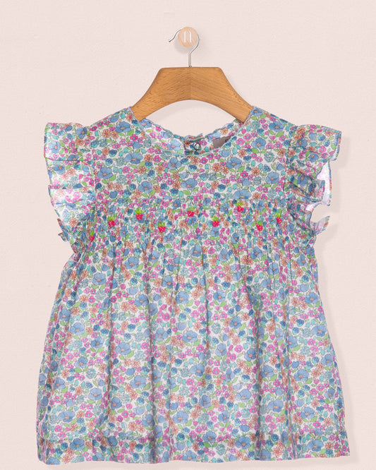 Floral dress on a hanger against a light background